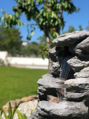 a stone fountain with a waterfall in a park at Villa Galicia in Caldas de Reis