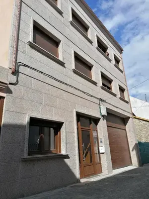 a gray brick building with a door and windows at Villa Galicia in Caldas de Reis