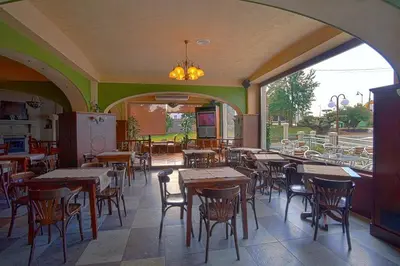 an empty restaurant with wooden tables and chairs at Pensión Bos in Bergondo
