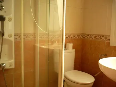 a bathroom with a shower and a toilet and a sink at Pensión Bos in Bergondo