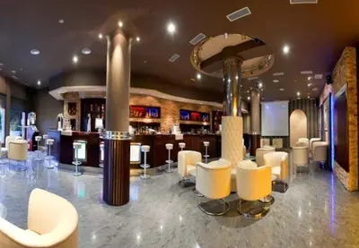 a bar with white chairs and a bar counter at Pensión Bos in Bergondo