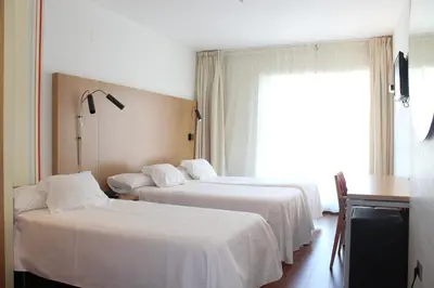 a hotel room with two beds and a window at Hotel Ril in Burela de Cabo