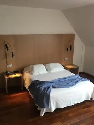 a bedroom with a bed with a blue blanket on it at Hotel Ril in Burela de Cabo