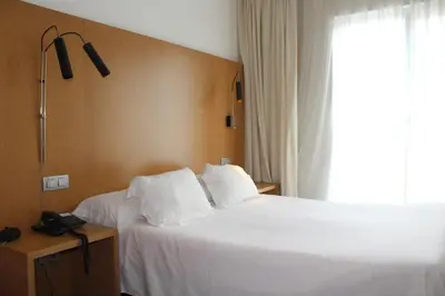 a hotel room with two beds and a window at Hotel Ril in Burela de Cabo
