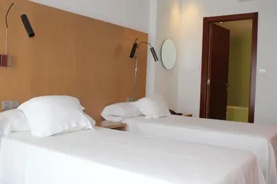 two beds sitting next to each other in a room at Hotel Ril in Burela de Cabo