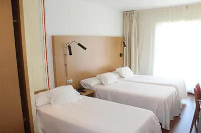 a hotel room with two beds and a window at Hotel Ril in Burela de Cabo