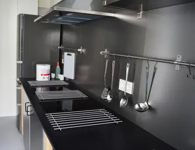 a kitchen with a black counter and utensils at Albergue Xabarín in Abadín