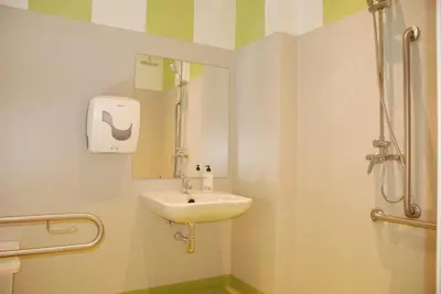a bathroom with a sink and a shower at Albergue Xabarín in Abadín