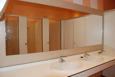 a bathroom with two sinks and a large mirror at Albergue Xabarín in Abadín