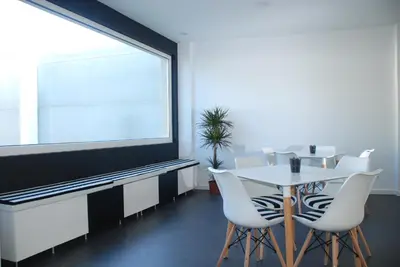 a dining room with a table and a large window at Albergue Xabarín in Abadín