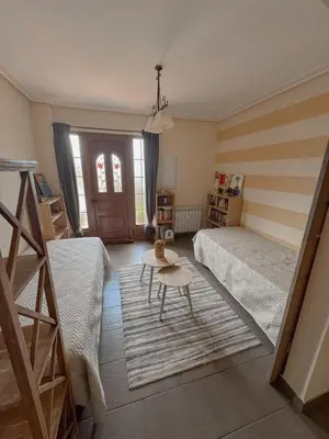 a bedroom with two beds and a table in it at Casa Idalia in Ourense
