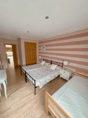 a bedroom with two beds and a table and chairs at Casa Idalia in Ourense