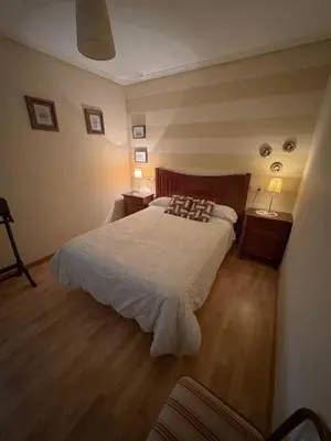 a bedroom with a large bed and two night stands at Casa Idalia in Ourense