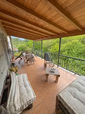 a covered patio with a couch and a table at Casa Idalia in Ourense