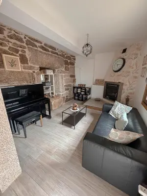 a living room with a black couch and a piano at Casa Idalia in Ourense