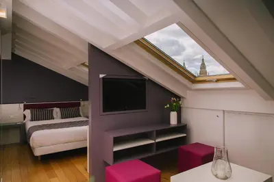 a room with a bed and a tv in a attic at Os Sobriños Do Pai in Santiago de Compostela