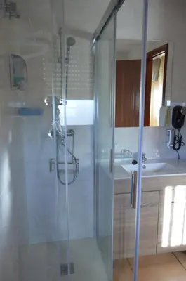 a bathroom with a glass shower and a sink at Hotel Restaurante Val in Antas de Ulla