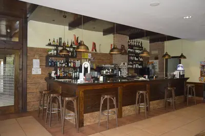 a bar in a restaurant with bar stools at Hotel Restaurante Val in Antas de Ulla
