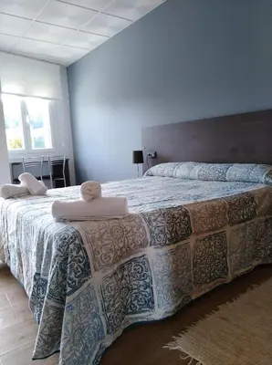 a bedroom with a large bed with a blanket at O Cruceiro in Palas de Rei