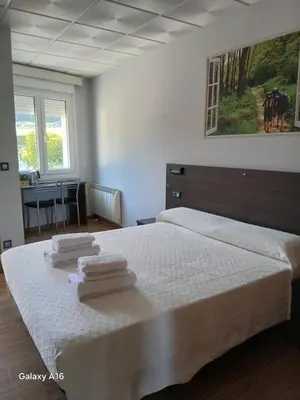a bedroom with a bed with towels on it at O Cruceiro in Palas de Rei