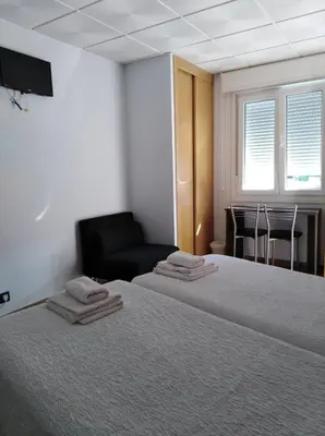 a room with a bed and a chair and a couch at O Cruceiro in Palas de Rei
