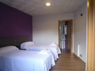 a room with two beds with white sheets at O Cruceiro in Palas de Rei