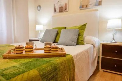 a bedroom with a bed with two cupcakes on it at Apartamento Centro Santiago in Santiago de Compostela