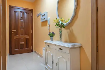 a bathroom with a mirror and a white cabinet with flowers at Apartamento Centro Santiago in Santiago de Compostela