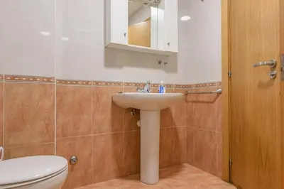 a bathroom with a sink and a toilet and a mirror at Apartamento Centro Santiago in Santiago de Compostela