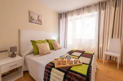 a bedroom with a bed with a tray of food on it at Apartamento Centro Santiago in Santiago de Compostela