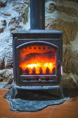a stove with a fire inside of it at Caserío da Castiñeira in Sas do Monte