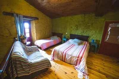 a bedroom with two beds and a window at Caserío da Castiñeira in Sas do Monte