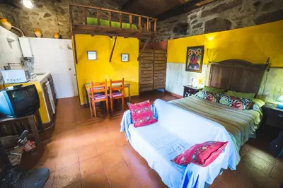 a bedroom with a bed and a tv and a kitchen at Caserío da Castiñeira in Sas do Monte