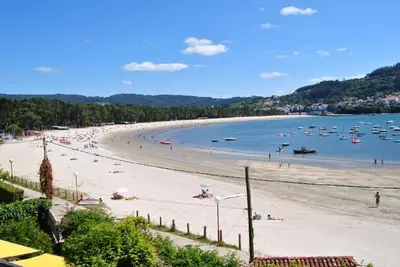 a beach with many people and boats in the water at Casa Cabanas in Cabañas