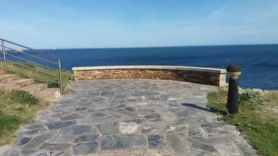 a stone walkway with the ocean in the background at Península de la paz in Lugo