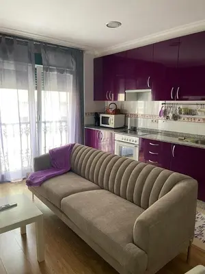 a couch in a kitchen with purple cabinets at Península de la paz in Lugo