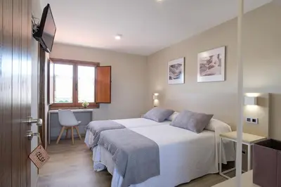 a bedroom with a bed and a desk and a window at Casa O Real in Boimorto