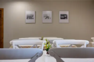 a row of white chairs in a room with pictures on the wall at Casa O Real in Boimorto