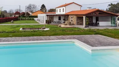 a swimming pool in front of a house at Casa O Real in Boimorto