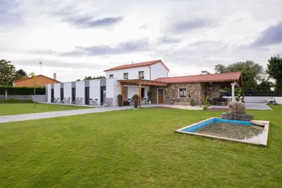 a house with a large yard in front of a building at Casa O Real in Boimorto