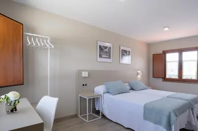 a bedroom with a bed and a table and a window at Casa O Real in Boimorto