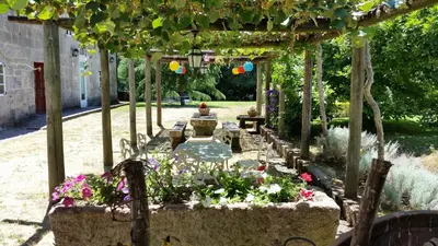 a garden with flowers and a pergola at Casa Grande de Soutullo in Coles