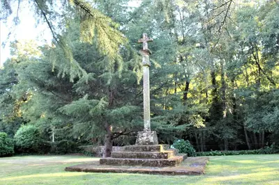 a statue in a park with a cross on it at Casa Grande de Soutullo in Coles