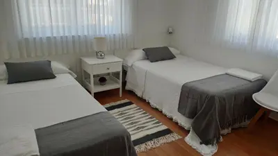 a bedroom with two beds and a table with a night stand at PortoSantiago in Portomarin