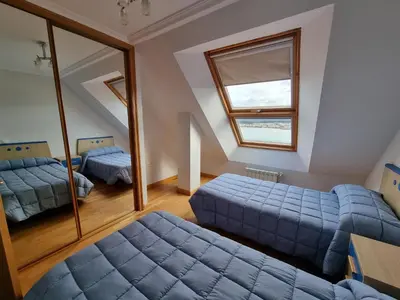 a bedroom with two beds and a mirror at Dúplex 4 dormitorios en Playa Rapadoira in Foz