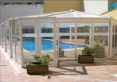 a greenhouse with potted plants next to a pool at Dúplex 4 dormitorios en Playa Rapadoira in Foz