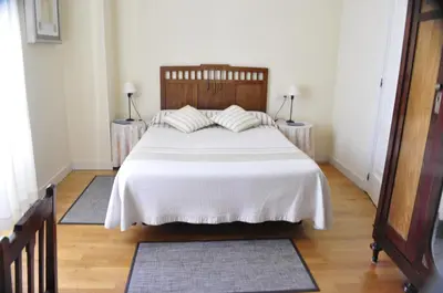 a bedroom with a large white bed with two tables at Alvarella in Villarmayor