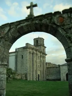 a stone building with a cross on top of it at Alvarella in Villarmayor