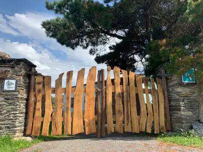 a wooden gate in front of a stone wall at Vivienda Vacacional Bioxana in Molejón