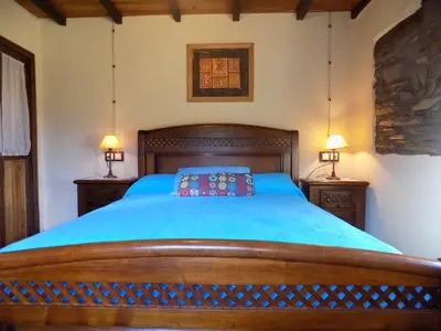 a bedroom with a wooden bed with two lamps at Vivienda Vacacional Bioxana in Molejón